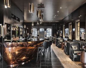 Hotel bar with dark marble counter, bar stools and leather lounge seating at Lady Stern Hotel.
