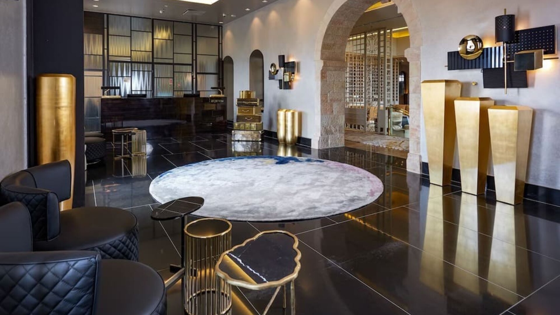 Concierge reception desk in a minimalist lobby with arched windows at Lady Stern Hotel.
