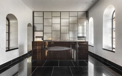 Lobby lounge with black tiled flooring, contemporary seating and gold decorative accents at Lady Stern Hotel.