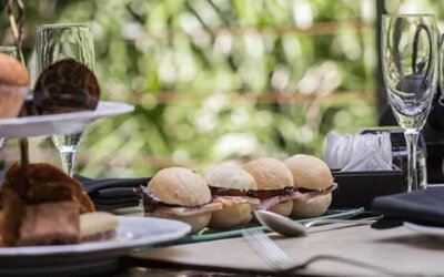 Table set with pastries, bread rolls, glassware and folded napkins against a leafy backdrop at Design Suites Buenos Aires.