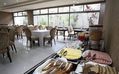Breakfast buffet displaying sliced cheese, cold meats, bread and cereal beside dining tables at HR Esmeralda Luxor.