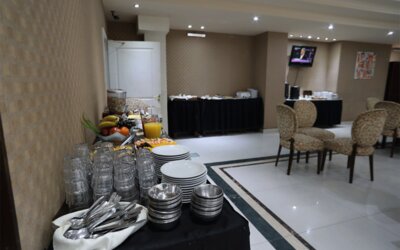 Breakfast buffet with stacked plates, glasses, cutlery, fresh fruit, juice and serving tables at HR Esmeralda Luxor.