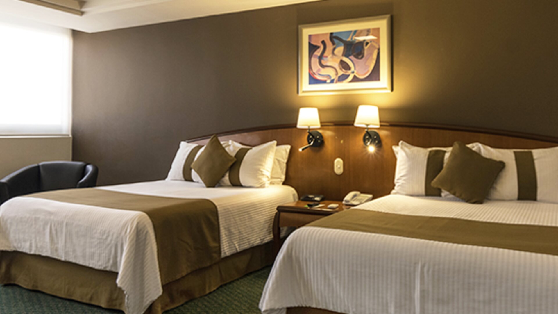 Twin guest room with two beds, white bedding, olive-green runners, framed artwork and bedside lamps at Hotel Misión Toreo Centro De Convenciones.