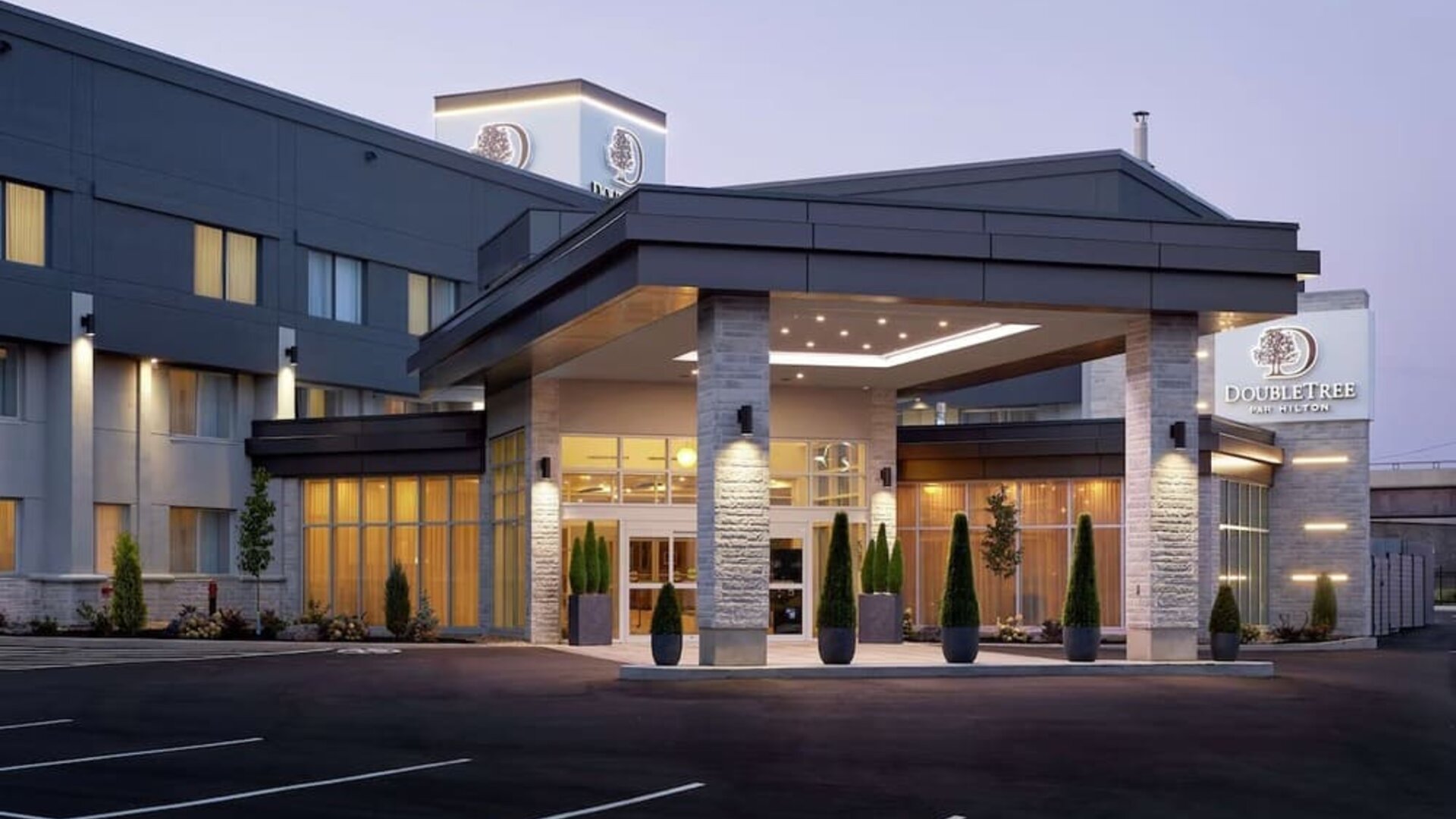 Hotel entrance and parking area at DoubleTree By Hilton Montreal Airport.