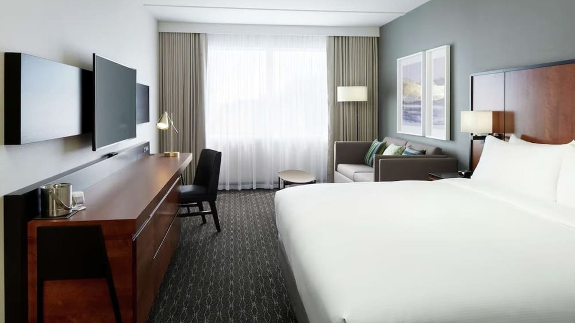 Standard day use room with work desk, TV, lounge area and private bathroom at DoubleTree By Hilton Montreal Airport.
