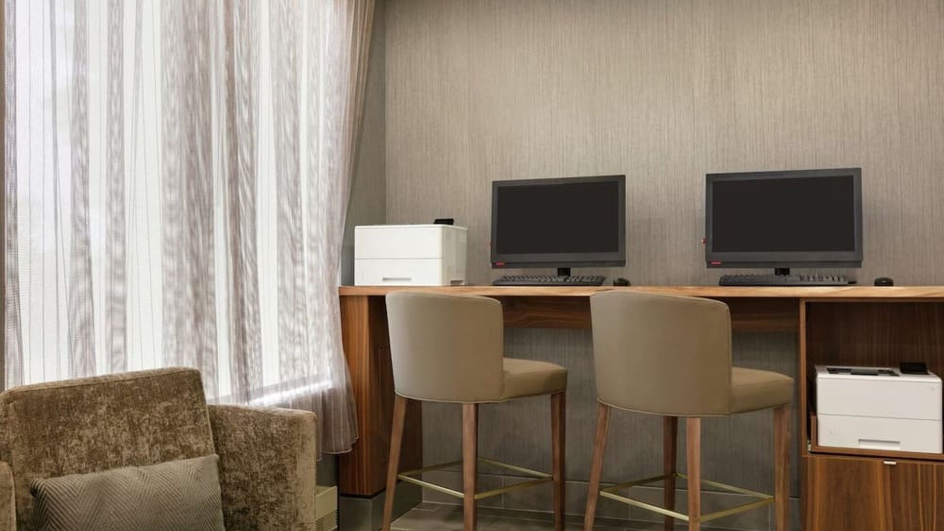 Business center with computers, printers and comfortable seating at the Embassy Suites by Hilton Montreal Airport.