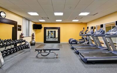 Fully equipped fitness center with treadmills and weights at the Hampton Inn by Hilton Toronto Airport Corporate Centre.