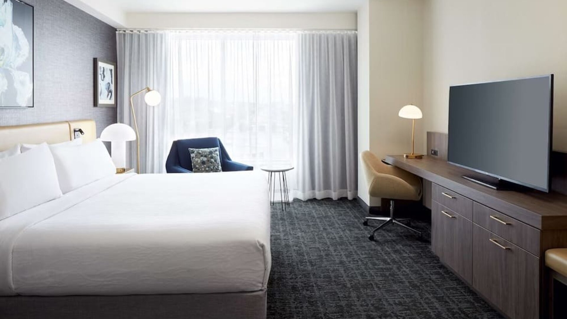 Day use room with king bed, TV, work desk and lounge area at Hilton Garden Inn Montreal Midtown.