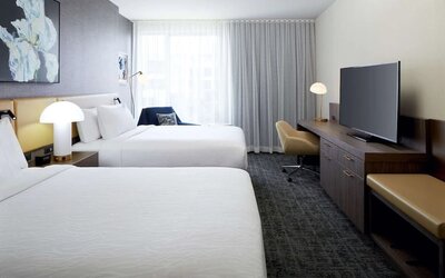 Day use twin room with TV, work desk and lounge area at Hilton Garden Inn Montreal Midtown.