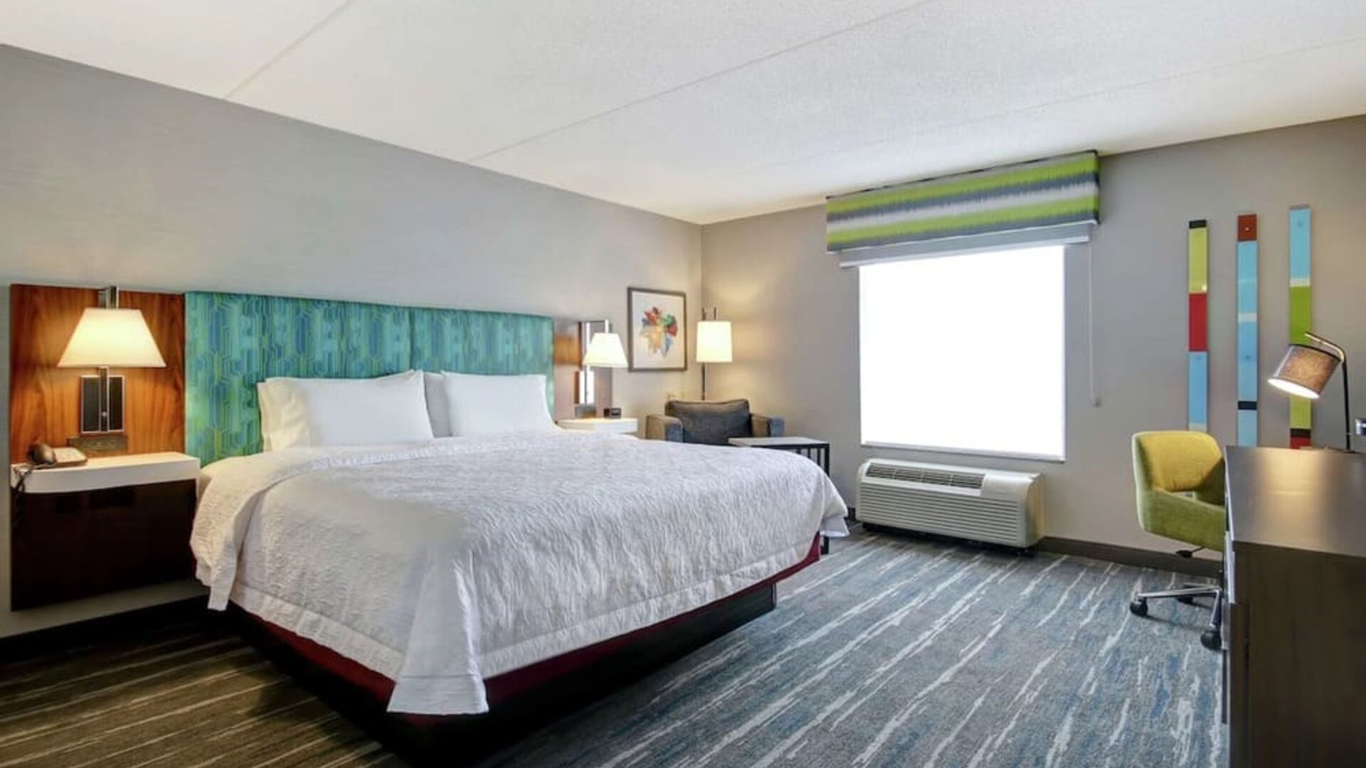 Bright day use room with king bed, work desk and private bathroom at the  Hampton Inn & Suites By Hilton Guelph.
