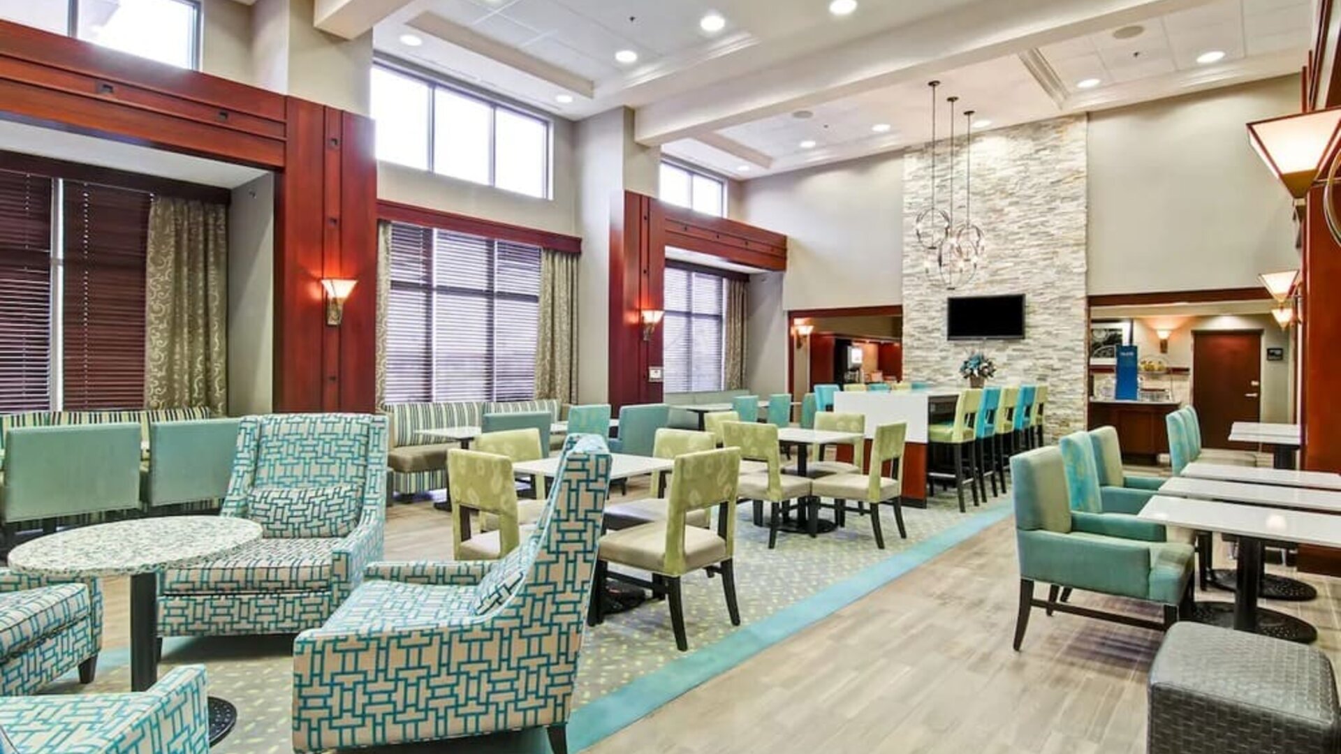 Hotel lounge and dining area with comfortable seating at the  Hampton Inn & Suites By Hilton Guelph.