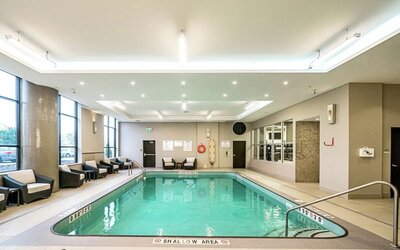 Relaxing indoor pool with lounge chairs at DoubleTree By Hilton Kitchener.