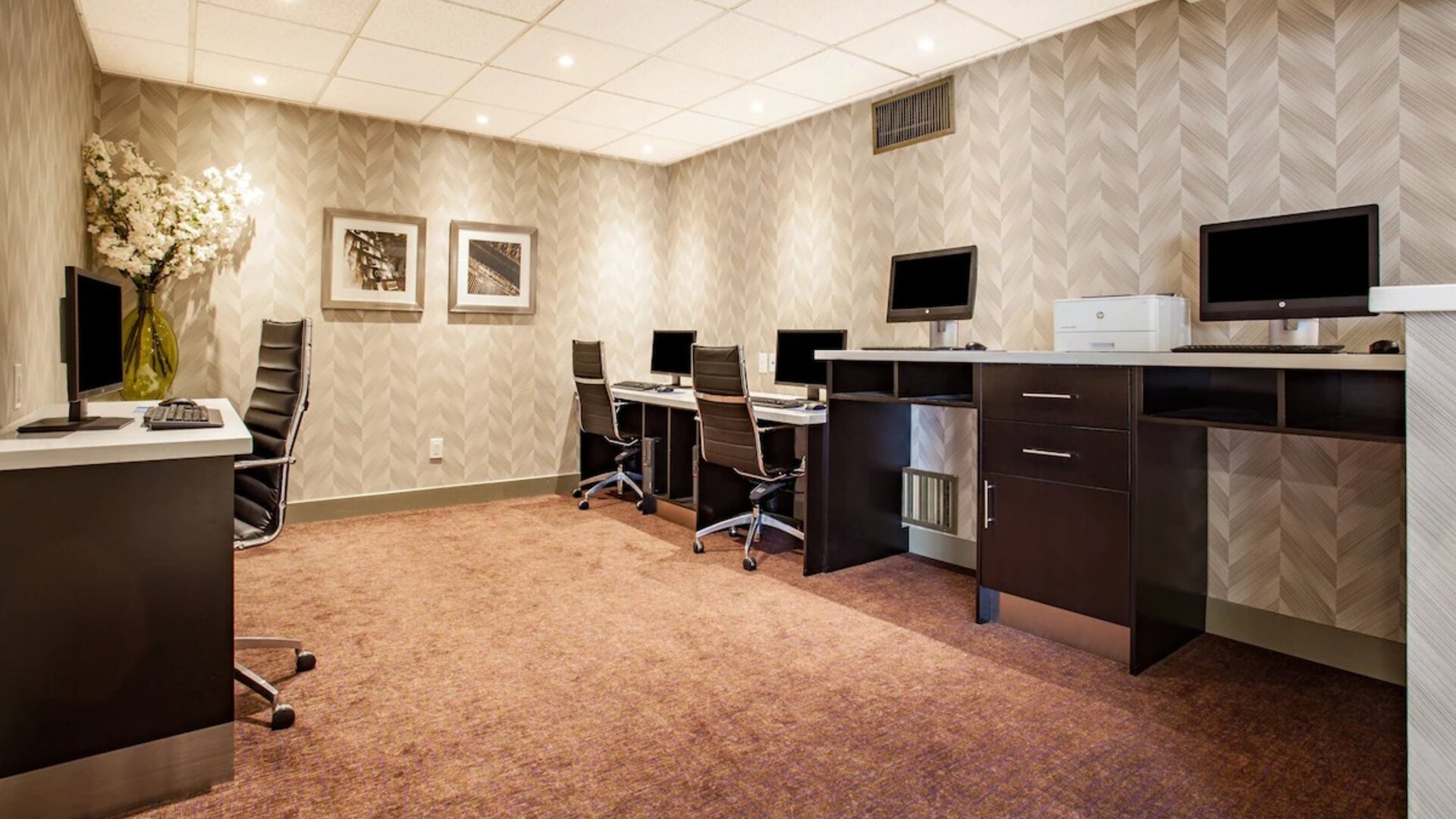 Professional business center with computers, printer and ergonomic chair at Holiday Inn Toronto International Airport.