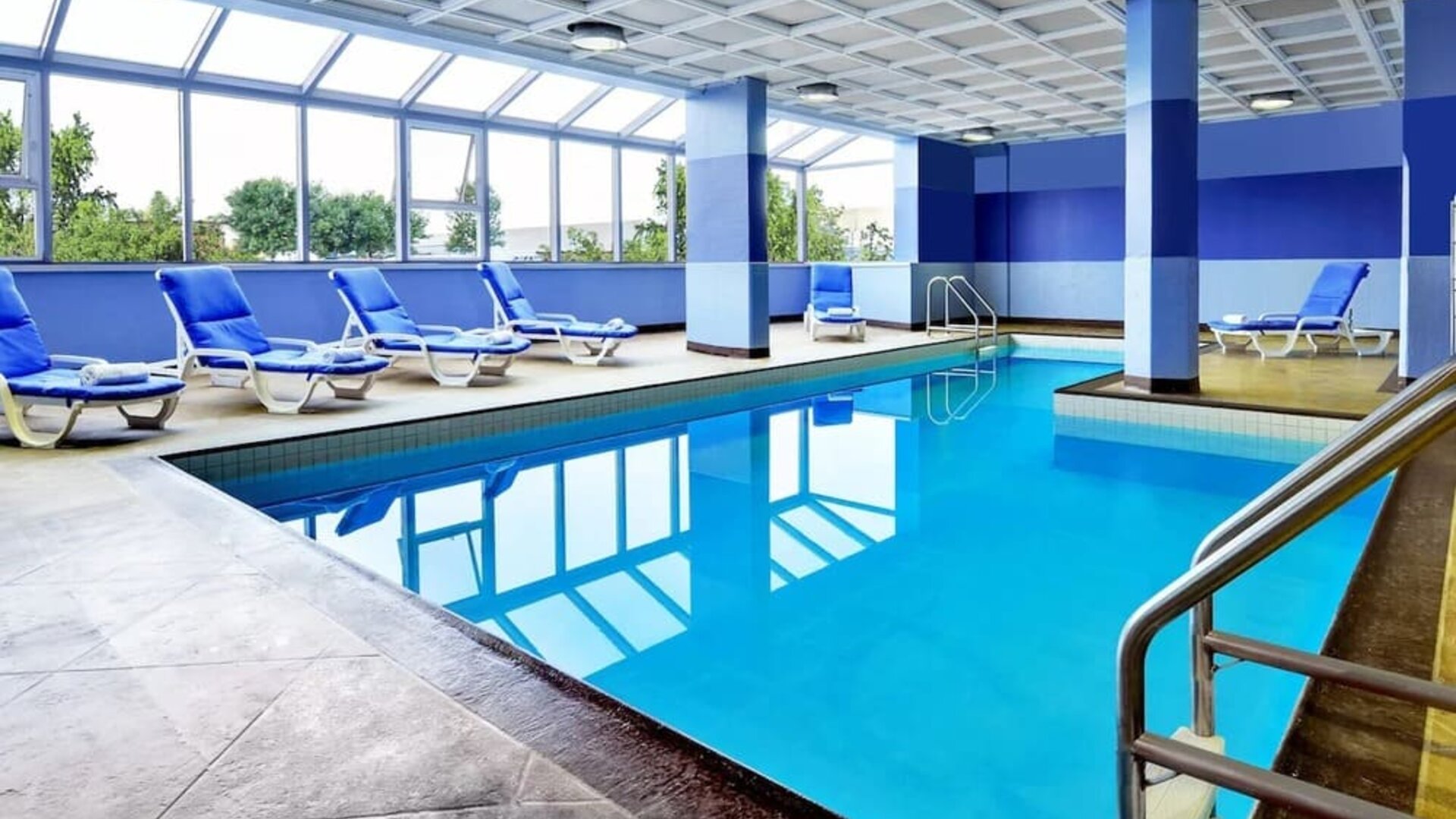 Relaxing indoor pool with lounge chairs at Four Points By Sheraton Toronto Mississauga.