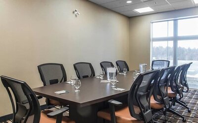 Professional meeting room with large windows and ergonomic chairs at Quality Inn & Suites Kingston.