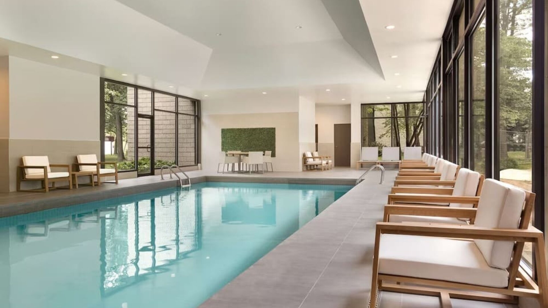 Relaxing indoor pool with lounge chairs at DoubleTree By Hilton Hotel Toronto Airport West.