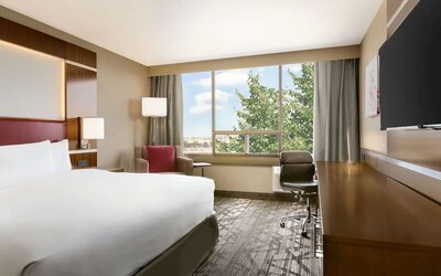 Day use room with large windows, TV, sofa, work desk and private bathroom at DoubleTree By Hilton Hotel Toronto Airport West.