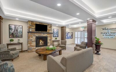 Lobby lounge area with fireplace at Days Inn & Suites By Wyndham Lindsay.