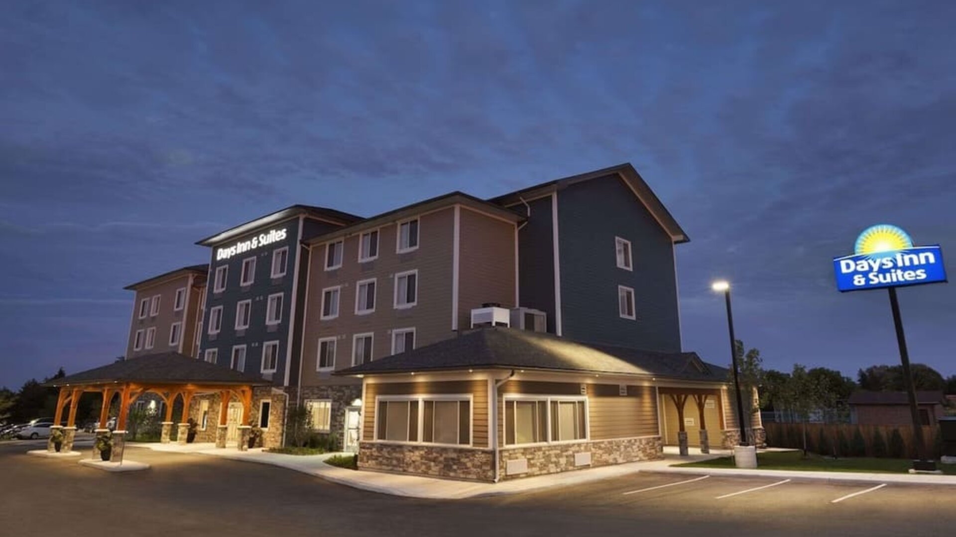 Hotel exterior and parking area at Days Inn & Suites By Wyndham Lindsay.