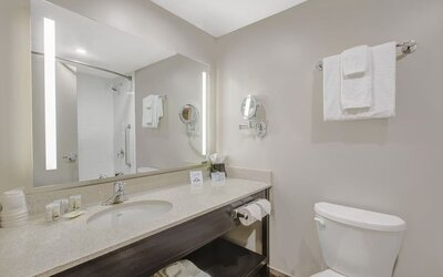 Private guest bathroom with shower and free toiletries at Days Inn & Suites By Wyndham Lindsay.