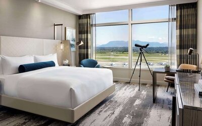 Day use room with large window, sofa, work desk and private bathroom at Fairmont Vancouver Airport - YVR Terminal Hotel.