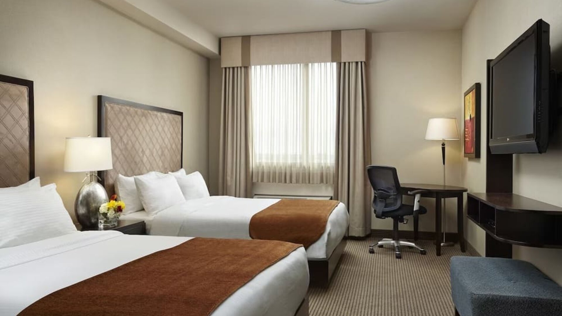 Day use twin room with TV and work desk at Acclaim Hotel Calgary Airport.