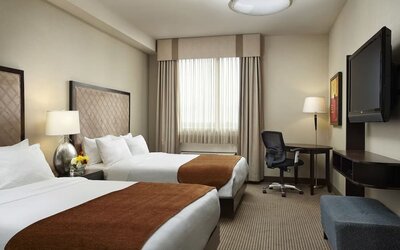 Day use twin room with TV and work desk at Acclaim Hotel Calgary Airport.