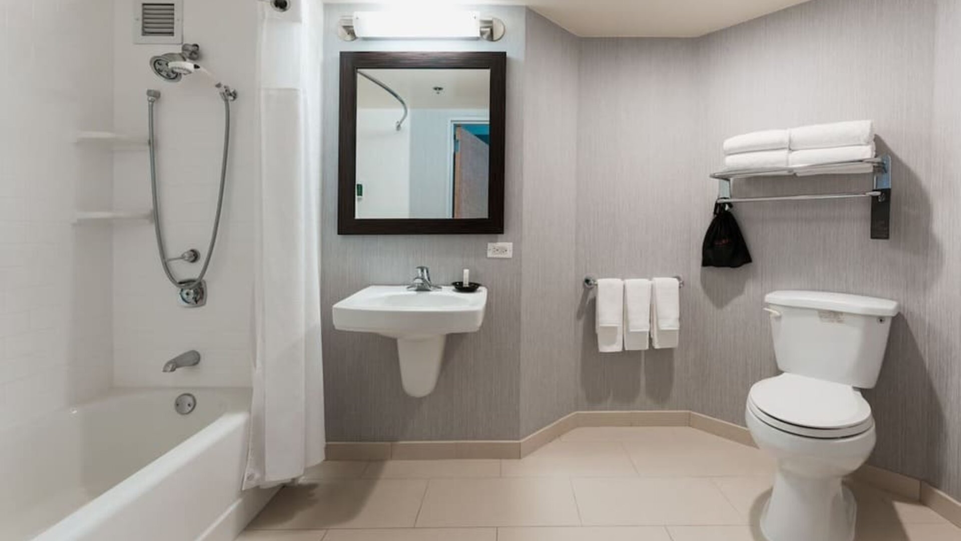 Guest bathroom with shower and tub at Courtyard By Marriott Los Angeles LAX/Century Boulevard.