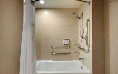 Guest bathroom with shower and tub at Cambria Suites Denver Airport.