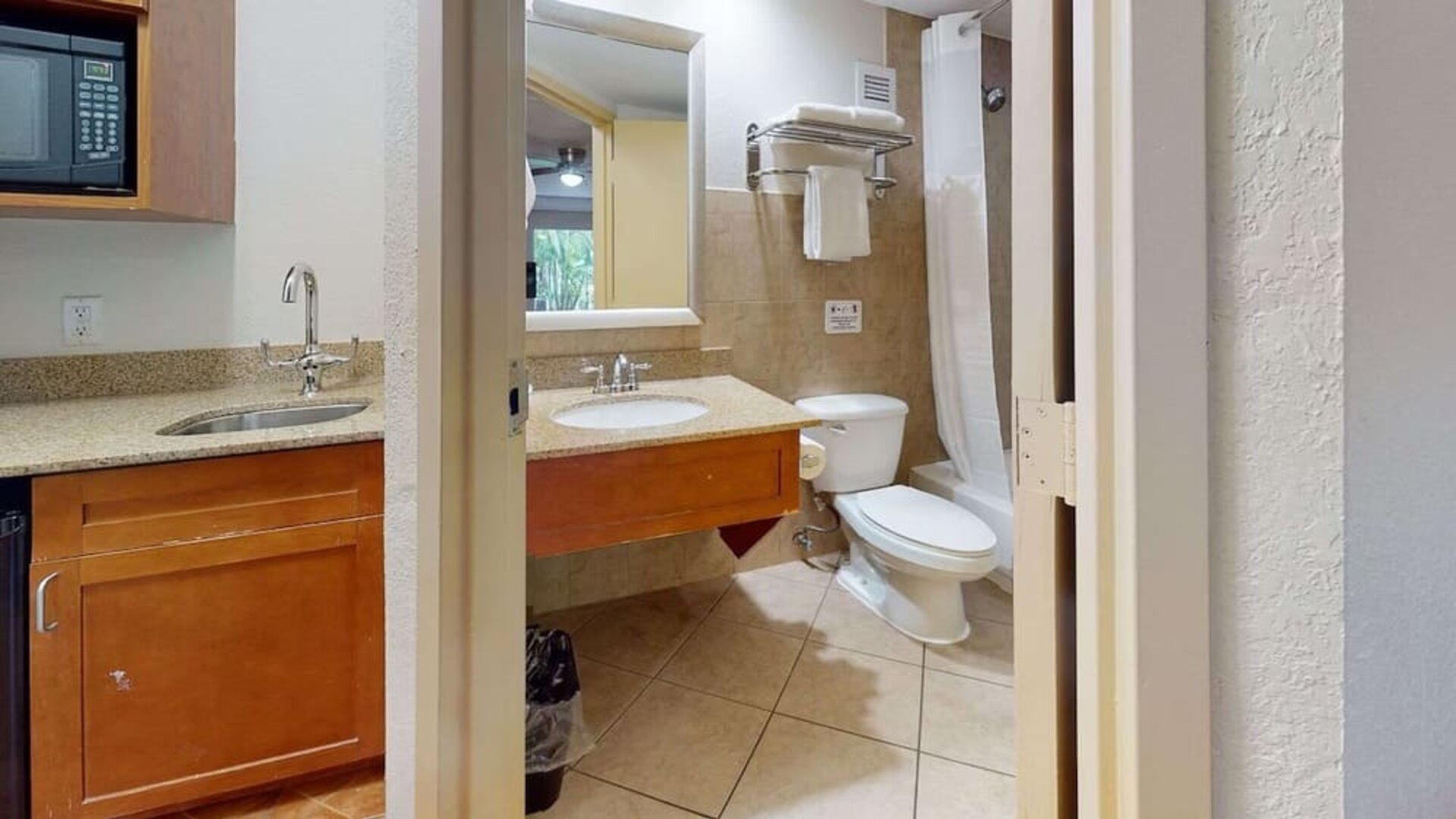 Guest bathroom with shower and tub at Rodeway Inn & Suites Fort Lauderdale Airport & Cruise Port.