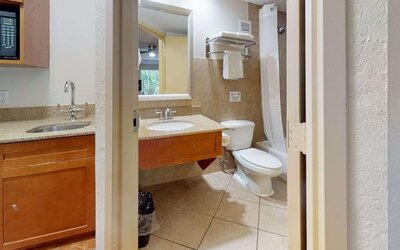 Guest bathroom with shower and tub at Rodeway Inn & Suites Fort Lauderdale Airport & Cruise Port.