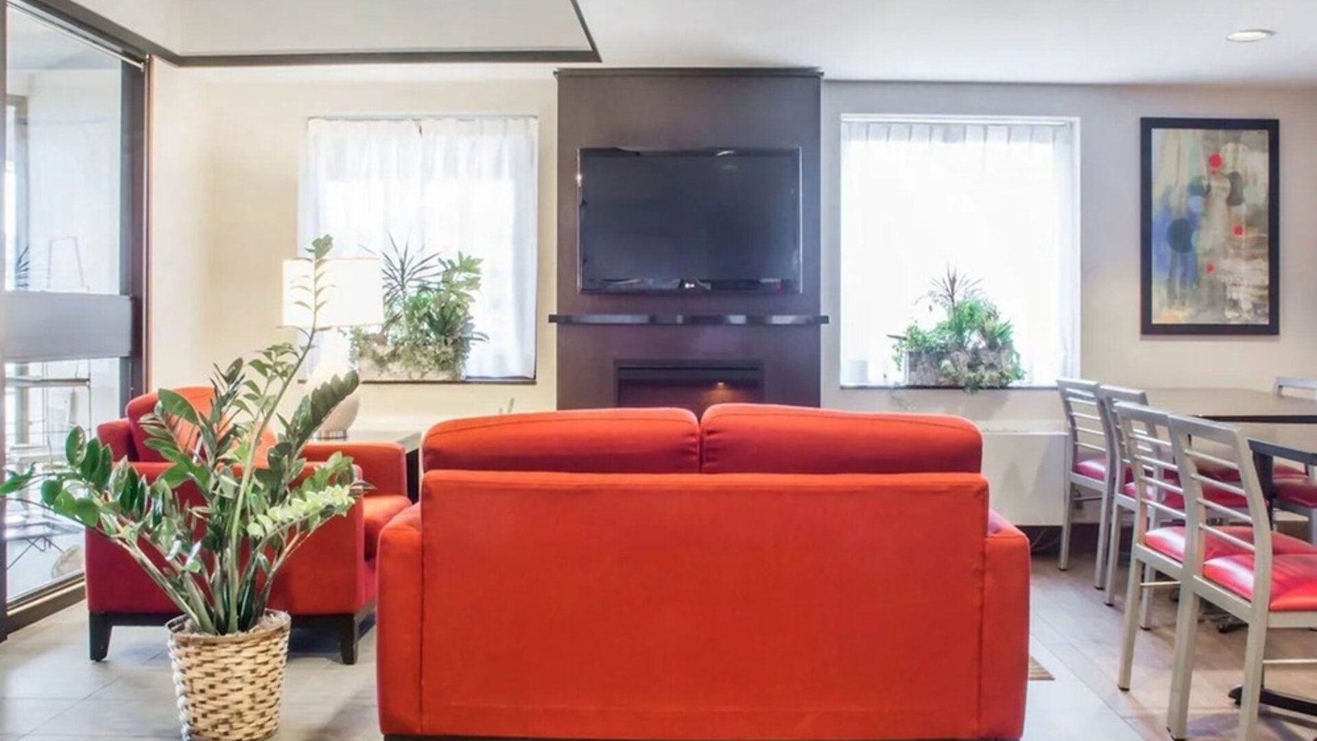 Lobby lounge with comfortable seating, TV screen and fireplace at Comfort Inn Parry Sound.
