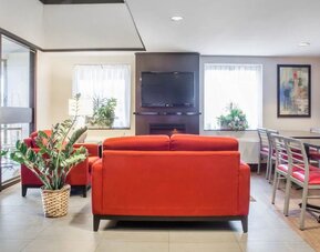 Lobby lounge with comfortable seating, TV screen and fireplace at Comfort Inn Parry Sound.