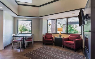 Lobby lounge with TV screen and fireplace at Comfort Inn Cobourg.