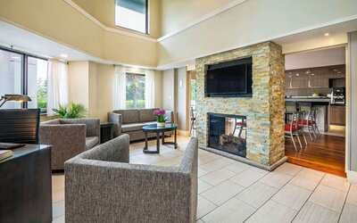Lobby lounge with TV screen and fireplace at Comfort Inn Newmarket.