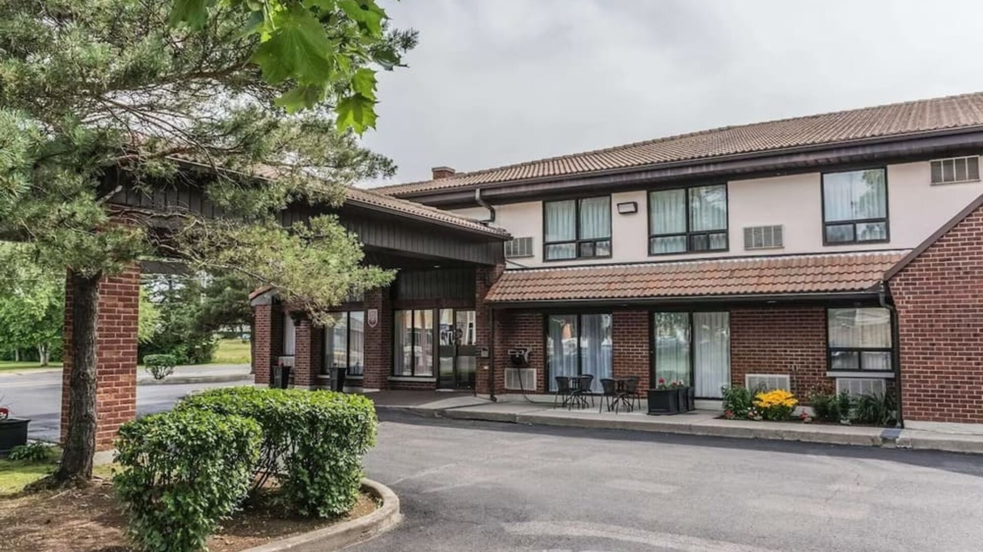 Hotel exterior with lounge area and parking at Comfort Inn Drummondville.