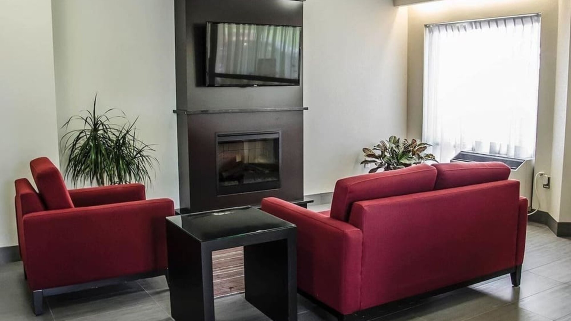 Lobby lounge with fireplace at Comfort Inn Boucherville.