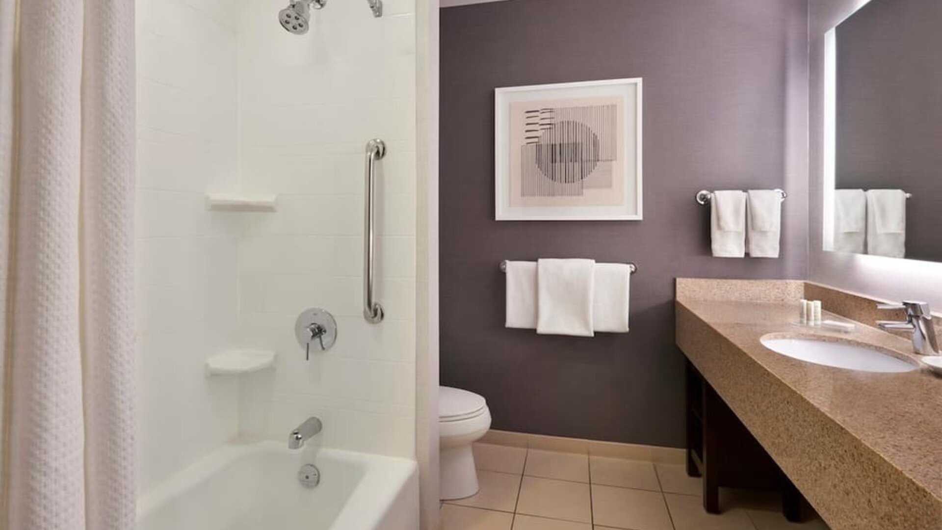 Guest bathroom with combined shower and tub at Courtyard By Marriott Waterloo St. Jacobs.