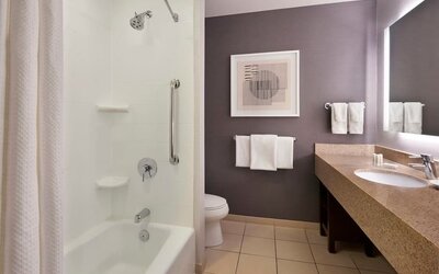 Guest bathroom with combined shower and tub at Courtyard By Marriott Waterloo St. Jacobs.