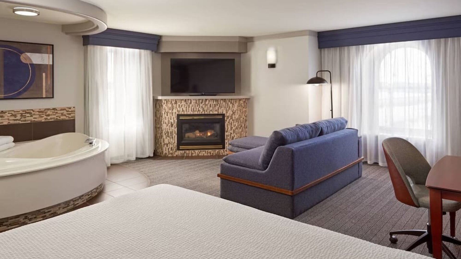 Day use suite with work desk, hot tub and living area with fireplace at Courtyard By Marriott Waterloo St. Jacobs.