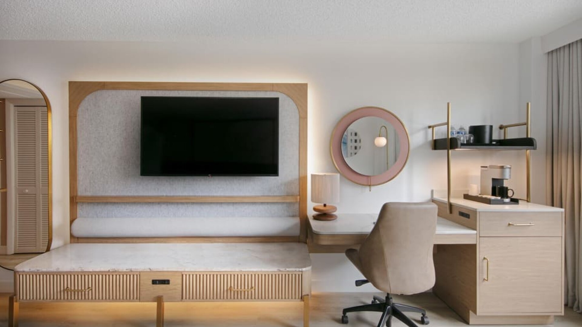 Day use room's workspace with TV screen and workdesk with ergonomic chair at Sonesta Miami Airport.