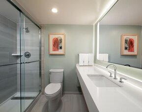 Private guest bathroom with shower and free toiletries at Sonesta Miami Airport.