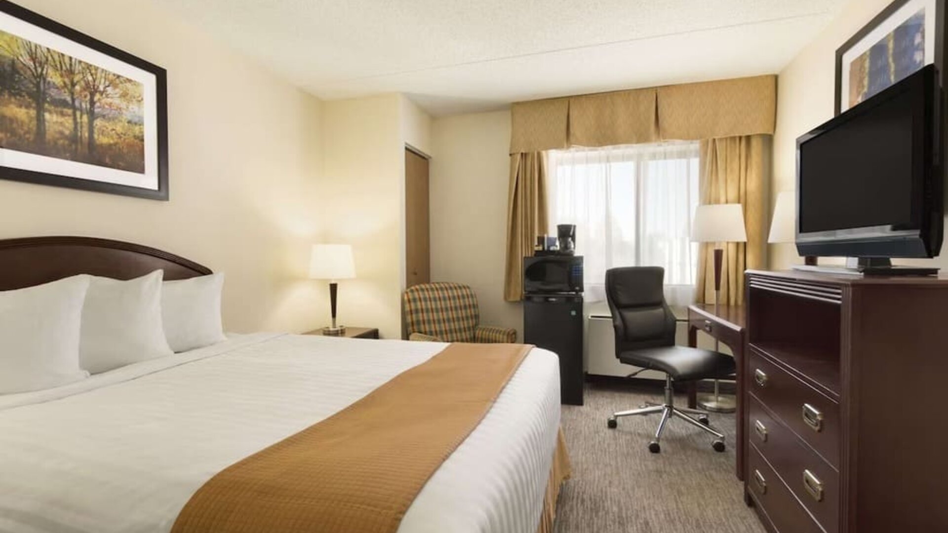 Bright day use room with TV, work desk and sofa at Travelodge Edmonton South.