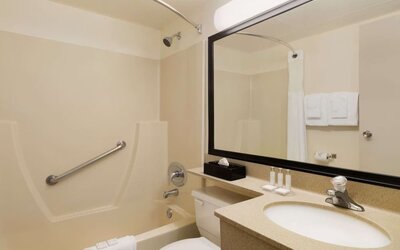 Guest bathroom with tub and free toiletries at Travelodge Edmonton South.