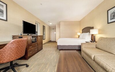 Day use room with TV, work desk and living area at Holiday Inn Lethbridge. 