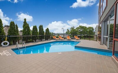 Hotel terrace with outdoor pool and lounge chairs at Holiday Inn Peterborough-Waterfront.