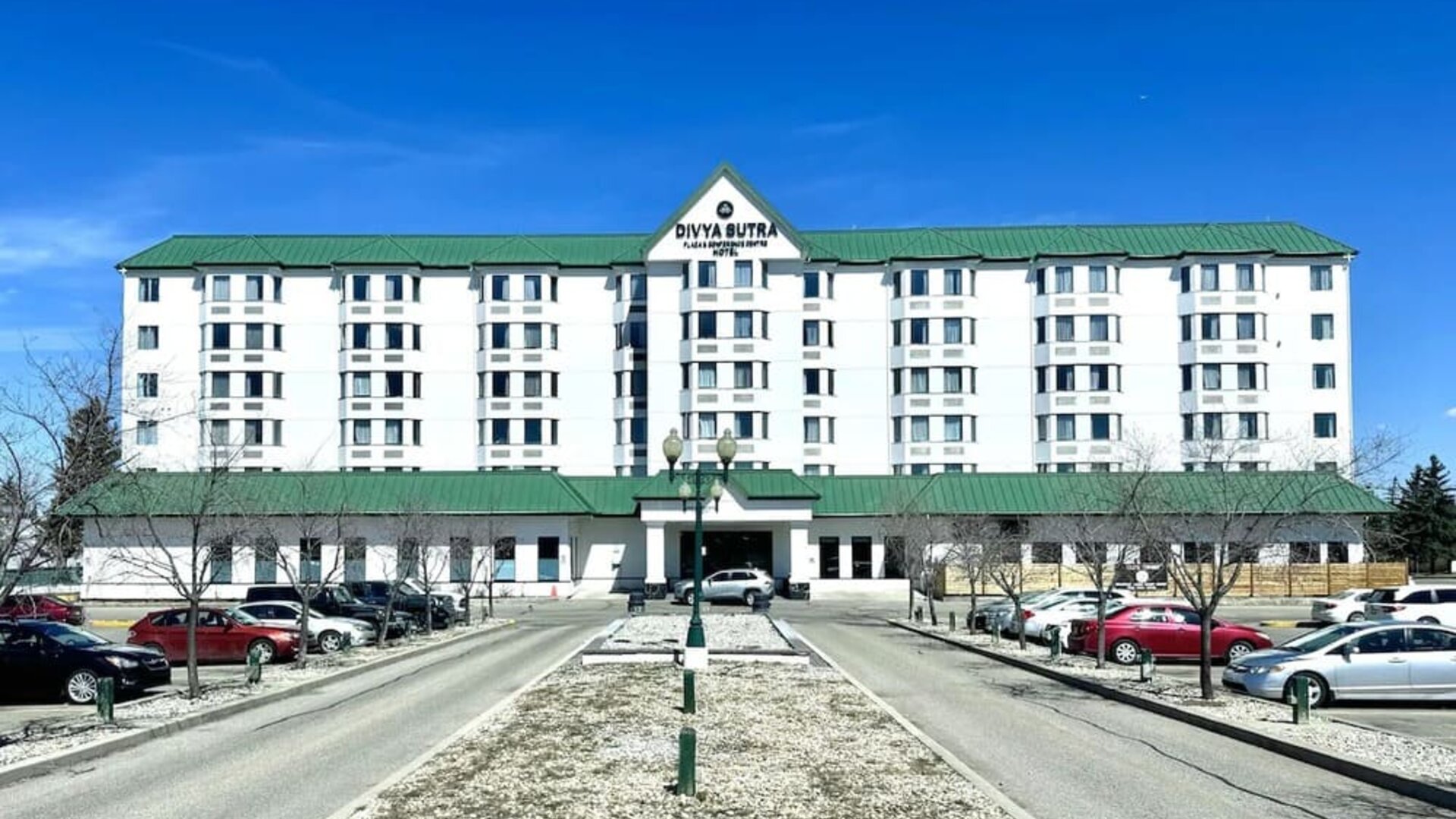 Hotel exterior and parking area at Divya Sutra Plaza & Conference Centre.
