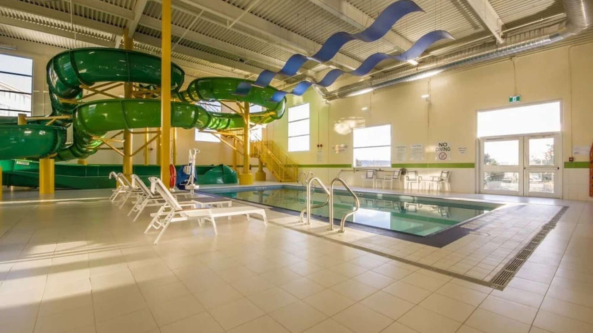 Indoor heated pool with lounge chairs and waterslides at Holiday Inn St. John's Conference Centre.