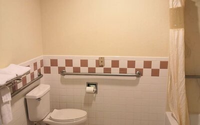 Guest bathroom with shower and tub at Scottish Inn & Suites.