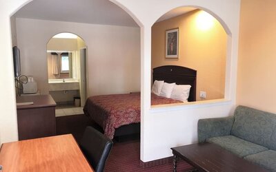 Day use room with sofa and work desk at Scottish Inn & Suites.